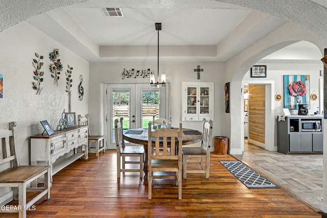 1624 Vinton Rd, Anthony, NM 88021 - dining area with arched walkways, a raised ceiling, wood finished floors, and french doors