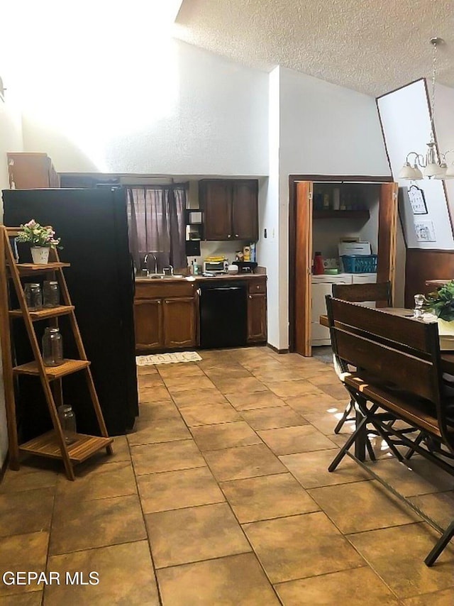 1624 Vinton Rd, Anthony, NM 88021 - kitchen featuring dishwasher, a textured ceiling, light tile patterned floors, dark brown cabinets, and freestanding refrigerator