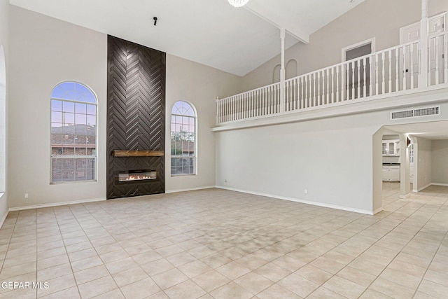 8921 Gemotes Pl, El Paso, TX 79907 - unfurnished living room featuring high vaulted ceiling, a fireplace, light tile patterned floors, and arched walkways