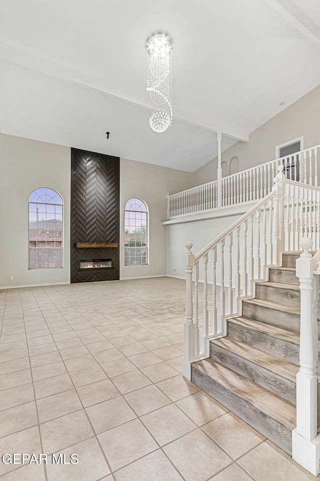 8921 Gemotes Pl, El Paso, TX 79907 - stairs with tile patterned flooring, a fireplace, and a chandelier