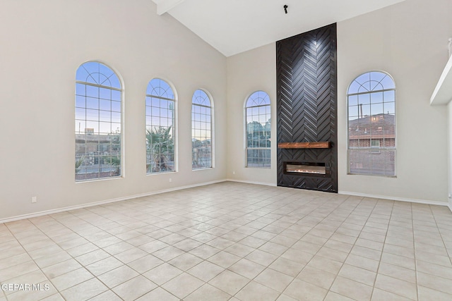 8921 Gemotes Pl, El Paso, TX 79907 - unfurnished living room with high vaulted ceiling, light tile patterned floors, healthy amount of natural light, a large fireplace, and beamed ceiling