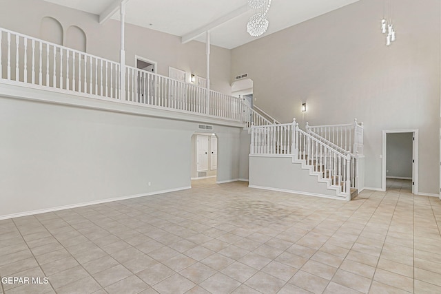 8921 Gemotes Pl, El Paso, TX 79907 - unfurnished living room with a towering ceiling, stairway, beam ceiling, tile patterned flooring, and arched walkways