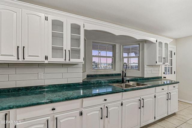 8921 Gemotes Pl, El Paso, TX 79907 - kitchen with tasteful backsplash, glass insert cabinets, light tile patterned floors, and white cabinetry