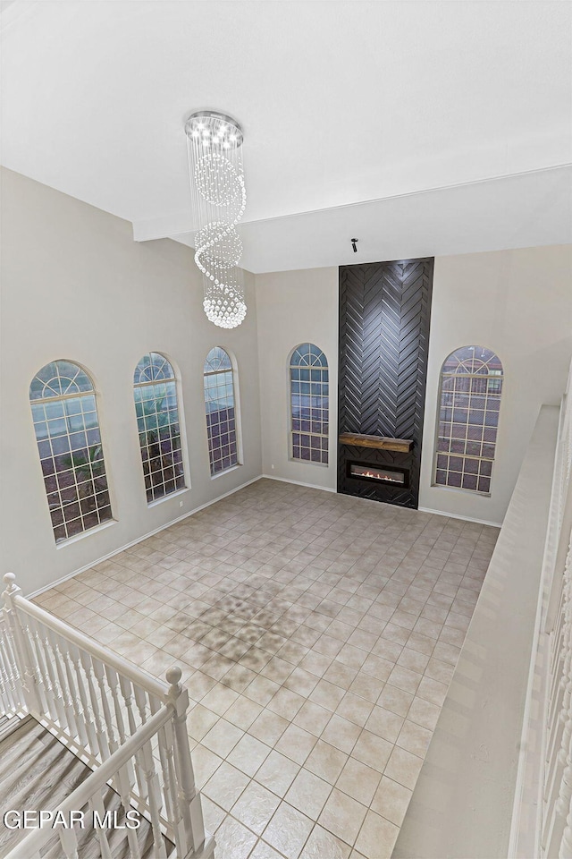 8921 Gemotes Pl, El Paso, TX 79907 - unfurnished living room with a chandelier, a fireplace, and light tile patterned floors