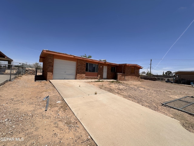 10445 Omega Cir, El Paso, TX 79924 - ranch-style home featuring a garage, concrete driveway, and brick siding