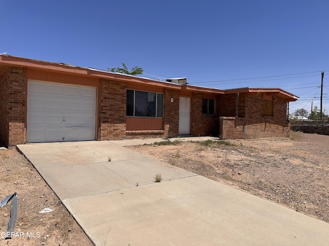 10445 Omega Cir, El Paso, TX 79924 - ranch-style home with brick siding, a garage, and driveway