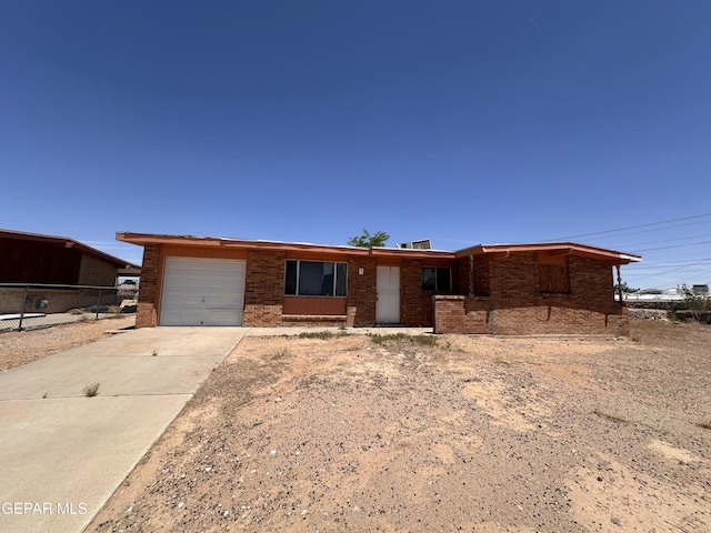 10445 Omega Cir, El Paso, TX 79924 - ranch-style house featuring an attached garage, brick siding, and concrete driveway