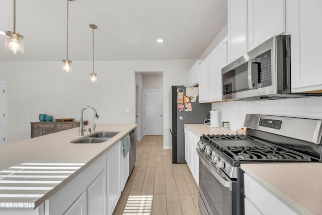 1649 Sam Dominguez, El Paso, TX 79928 - kitchen with stainless steel appliances, white cabinets, light countertops, pendant lighting, and light wood finished floors