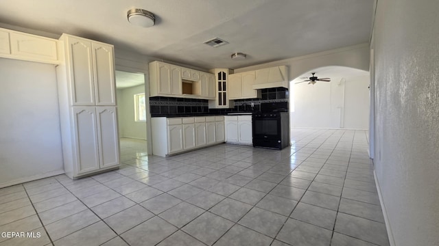 557 Bonampak Dr, San Elizario, TX 79849 - kitchen with black range, dark countertops, tasteful backsplash, ceiling fan, and light tile patterned flooring