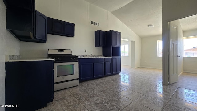 557 Bonampak Dr, San Elizario, TX 79849 - kitchen with stainless steel range with gas cooktop, plenty of natural light, light countertops, tile patterned floors, and high vaulted ceiling