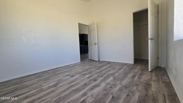 557 Bonampak Dr, San Elizario, TX 79849 - unfurnished bedroom with wood finished floors, a closet, and a walk in closet