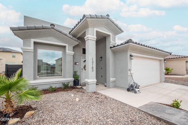 13163 Emerald Isle St, El Paso, TX 79928 - view of front facade featuring stucco siding, concrete driveway, an attached garage, and a tiled roof