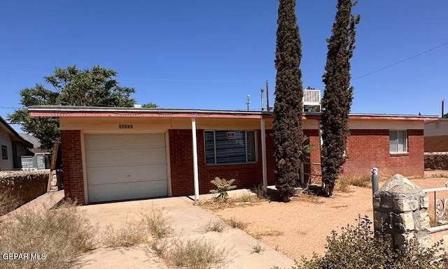 10333 Shoshone St, El Paso, TX 79924 - ranch-style home with brick siding, concrete driveway, and an attached garage