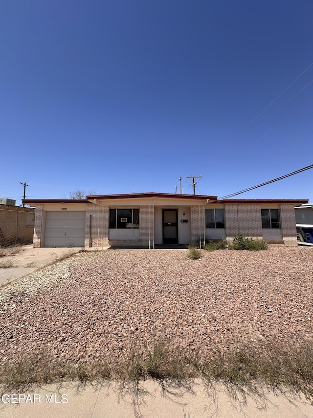 10561 Champlain St, El Paso, TX 79924 - view of front of house featuring brick siding, a garage, and driveway