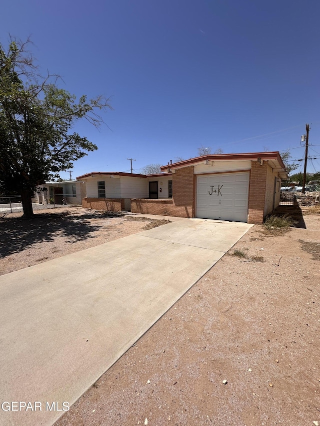 10529 Champlain St, El Paso, TX 79924 - view of front of home with driveway, brick siding, and an attached garage
