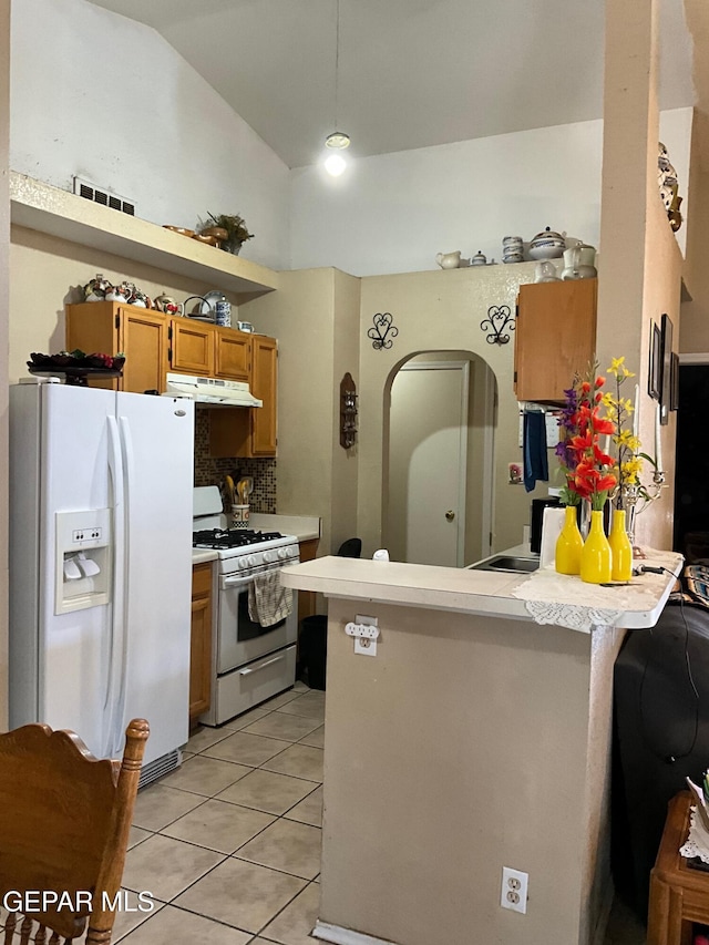 11816 Oxcart Run St, El Paso, TX 79936 - kitchen with white appliances, under cabinet range hood, a peninsula, light countertops, and lofted ceiling
