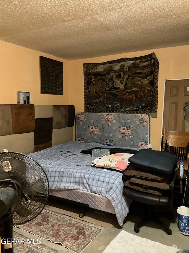 11816 Oxcart Run St, El Paso, TX 79936 - bedroom featuring a textured ceiling and concrete floors