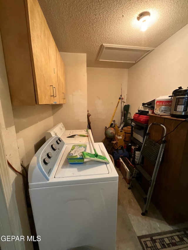 11816 Oxcart Run St, El Paso, TX 79936 - laundry room featuring washing machine and dryer, cabinet space, a textured ceiling, and attic access