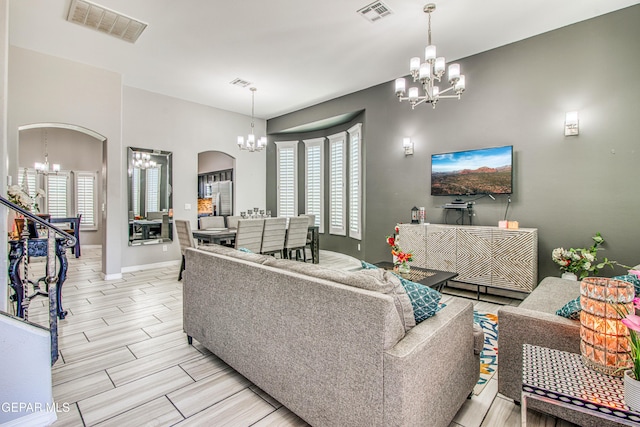 12571 New Dawn Dr, El Paso, TX 79928 - living room featuring a chandelier, arched walkways, and wood tiled floors