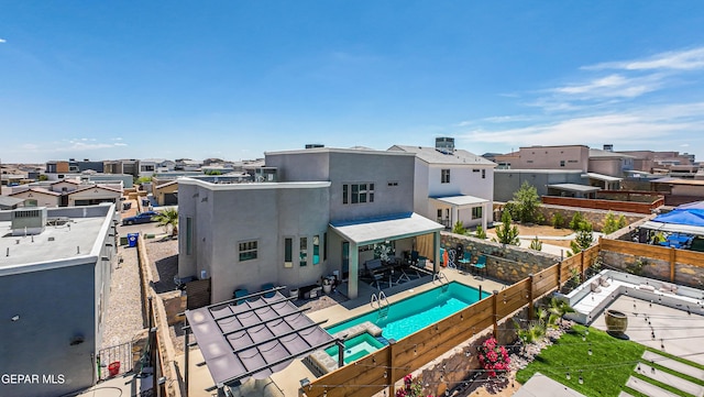 12571 New Dawn Dr, El Paso, TX 79928 - rear view of property featuring a residential view, a fenced backyard, stucco siding, and a pool with connected hot tub
