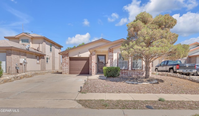 5609 Rick Husband Dr, El Paso, TX 79934 - view of front of property with concrete driveway, brick siding, and an attached garage