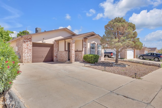 5609 Rick Husband Dr, El Paso, TX 79934 - view of front of house featuring an attached garage, brick siding, and driveway
