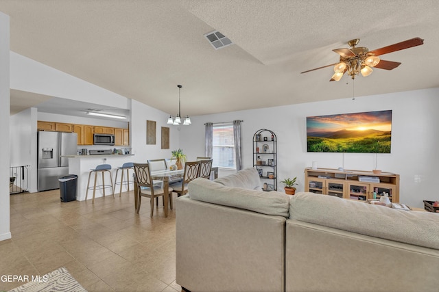 5609 Rick Husband Dr, El Paso, TX 79934 - living area featuring vaulted ceiling, ceiling fan, a chandelier, and a textured ceiling