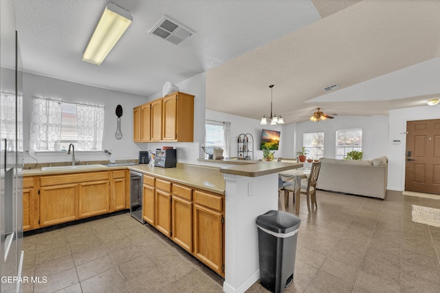 5609 Rick Husband Dr, El Paso, TX 79934 - kitchen featuring a peninsula, dishwasher, lofted ceiling, light countertops, and open floor plan