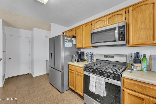5609 Rick Husband Dr, El Paso, TX 79934 - kitchen with stainless steel appliances, light countertops, and a textured ceiling