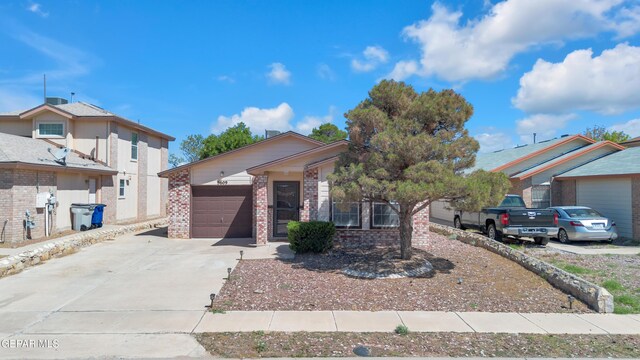 5609 Rick Husband Dr, El Paso, TX 79934 - view of front facade with driveway, a garage, and brick siding