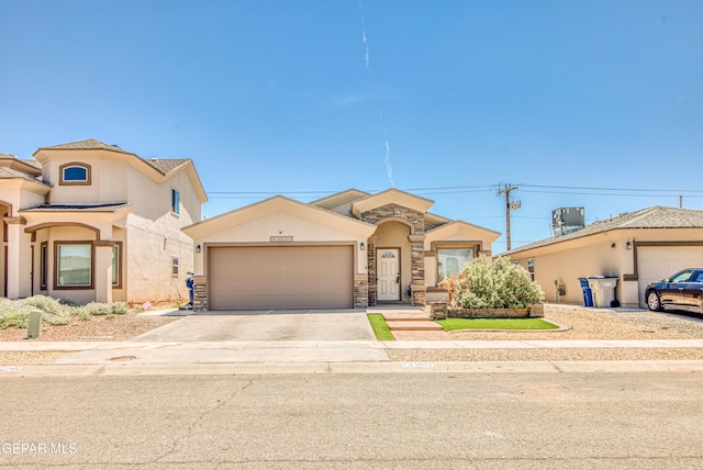 12140 Mesquite Thorn Dr, El Paso, TX 79934 - mediterranean / spanish-style house featuring stucco siding, a garage, driveway, and stone siding