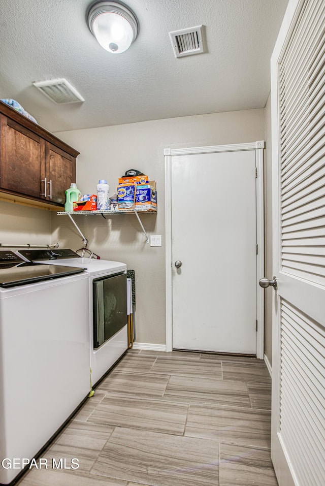 12140 Mesquite Thorn Dr, El Paso, TX 79934 - washroom with washing machine and clothes dryer, cabinet space, a textured ceiling, and wood finish floors