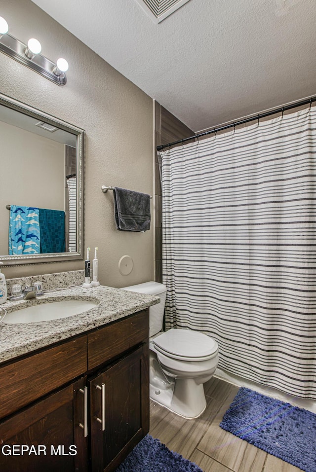 12140 Mesquite Thorn Dr, El Paso, TX 79934 - full bath featuring vanity, a textured ceiling, wood finished floors, and a shower with shower curtain