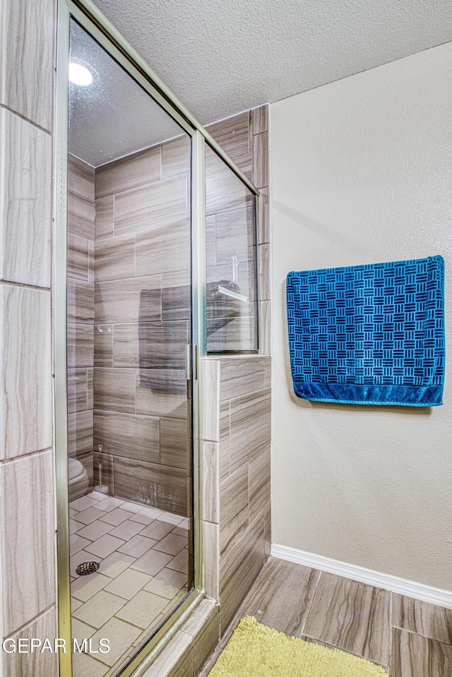 12140 Mesquite Thorn Dr, El Paso, TX 79934 - full bathroom with a shower stall, a textured ceiling, and wood finished floors