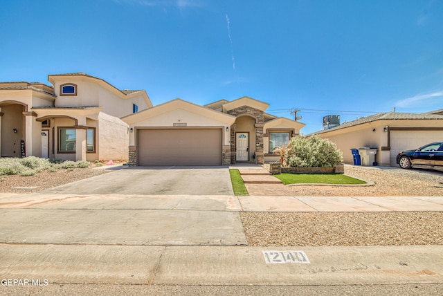 12140 Mesquite Thorn Dr, El Paso, TX 79934 - mediterranean / spanish-style house with a garage, concrete driveway, stucco siding, and stone siding