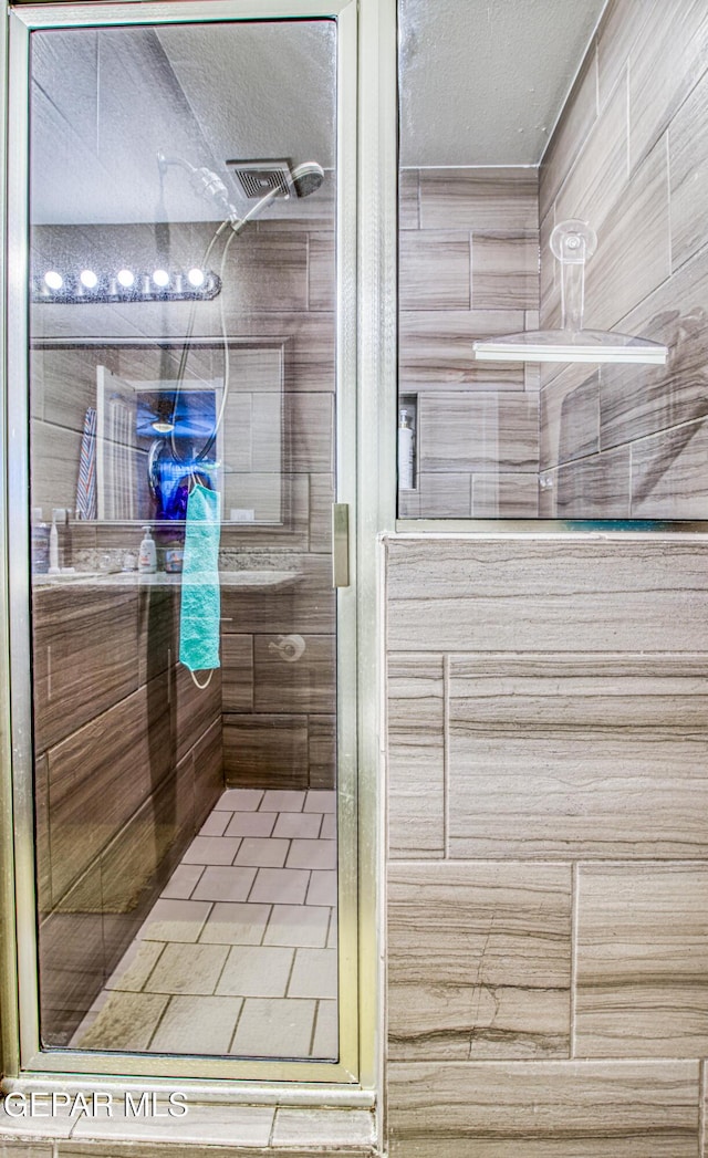 12140 Mesquite Thorn Dr, El Paso, TX 79934 - full bath featuring a shower stall, a textured ceiling, and tile patterned flooring