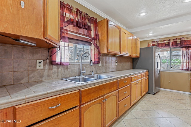 3417 Thomason Ave, El Paso, TX 79904 - kitchen with crown molding, a textured ceiling, tile countertops, stainless steel fridge, and light tile patterned floors
