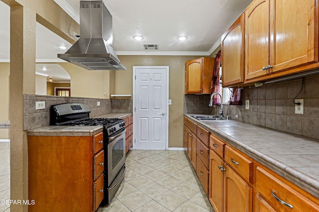 3417 Thomason Ave, El Paso, TX 79904 - kitchen featuring island exhaust hood, gas stove, tile countertops, light tile patterned floors, and crown molding