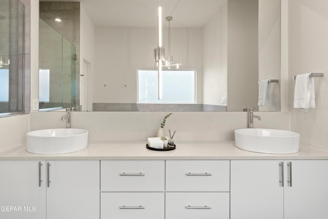 1837 Bridle, El Paso, TX 79911 - full bathroom with double vanity, a chandelier, and a shower with shower door