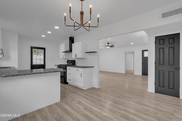 10113 Shenandoah St, El Paso, TX 79924 - kitchen featuring black gas range oven, wall chimney range hood, white cabinets, recessed lighting, and light wood finished floors
