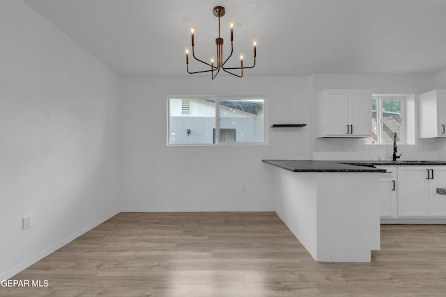 10113 Shenandoah St, El Paso, TX 79924 - kitchen featuring white cabinetry, a chandelier, light wood-style flooring, and pendant lighting