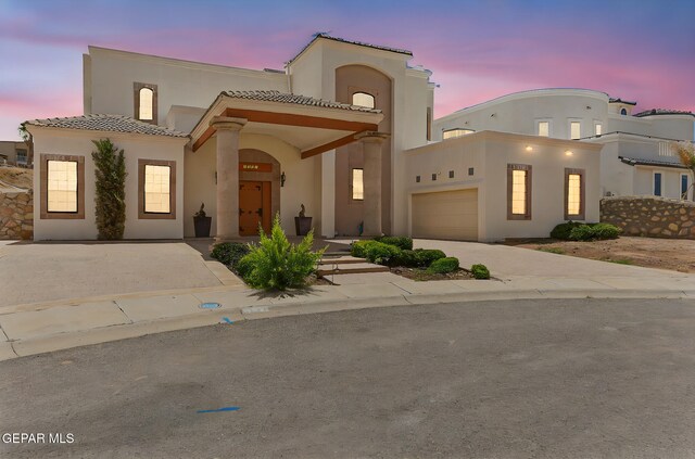 6514 Franklin Cove Place, El Paso, TX 79912 - mediterranean / spanish house with a tiled roof, stucco siding, an attached garage, and concrete driveway