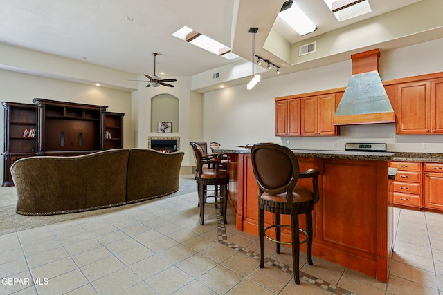 6514 Franklin Cove Place, El Paso, TX 79912 - kitchen featuring custom range hood, light tile patterned floors, a ceiling fan, a fireplace, and open floor plan