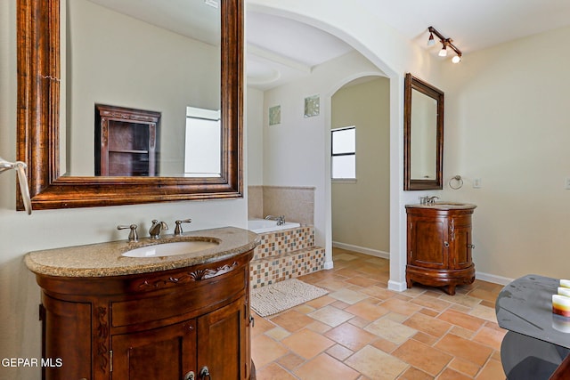 6514 Franklin Cove Place, El Paso, TX 79912 - full bathroom with two vanities, a bath, and stone tile flooring