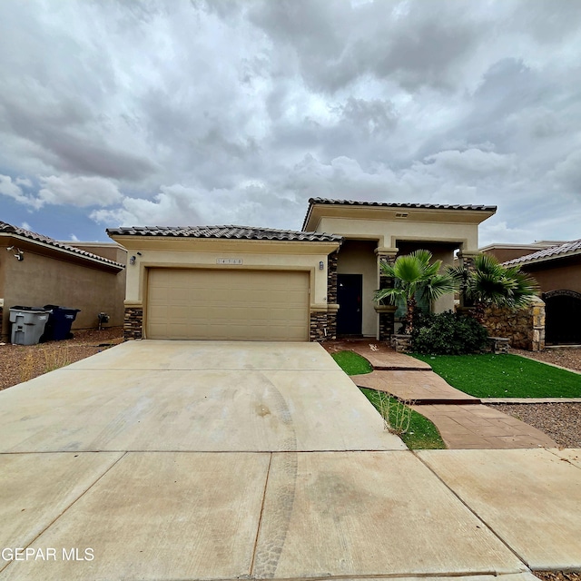 14368 Angel D Garcia Ct, El Paso, TX 79938 - mediterranean / spanish home featuring stucco siding, stone siding, driveway, an attached garage, and a tiled roof