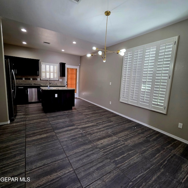 14368 Angel D Garcia Ct, El Paso, TX 79938 - kitchen with freestanding refrigerator, a kitchen island, a chandelier, light countertops, and backsplash