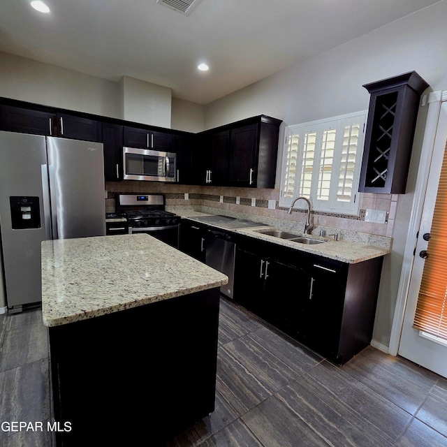 14368 Angel D Garcia Ct, El Paso, TX 79938 - kitchen with appliances with stainless steel finishes, backsplash, a center island, light stone counters, and recessed lighting