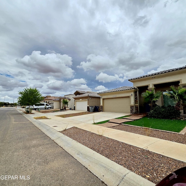 14368 Angel D Garcia Ct, El Paso, TX 79938 - mediterranean / spanish home with driveway, stucco siding, an attached garage, and a tile roof