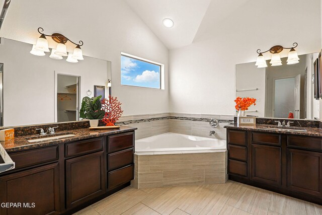 11353 W Ranch Ct, El Paso, TX 79934 - bathroom featuring two vanities, a bath, a chandelier, and vaulted ceiling