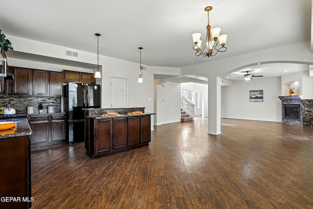11353 W Ranch Ct, El Paso, TX 79934 - kitchen with freestanding refrigerator, arched walkways, dark wood-type flooring, a center island, and dark brown cabinets